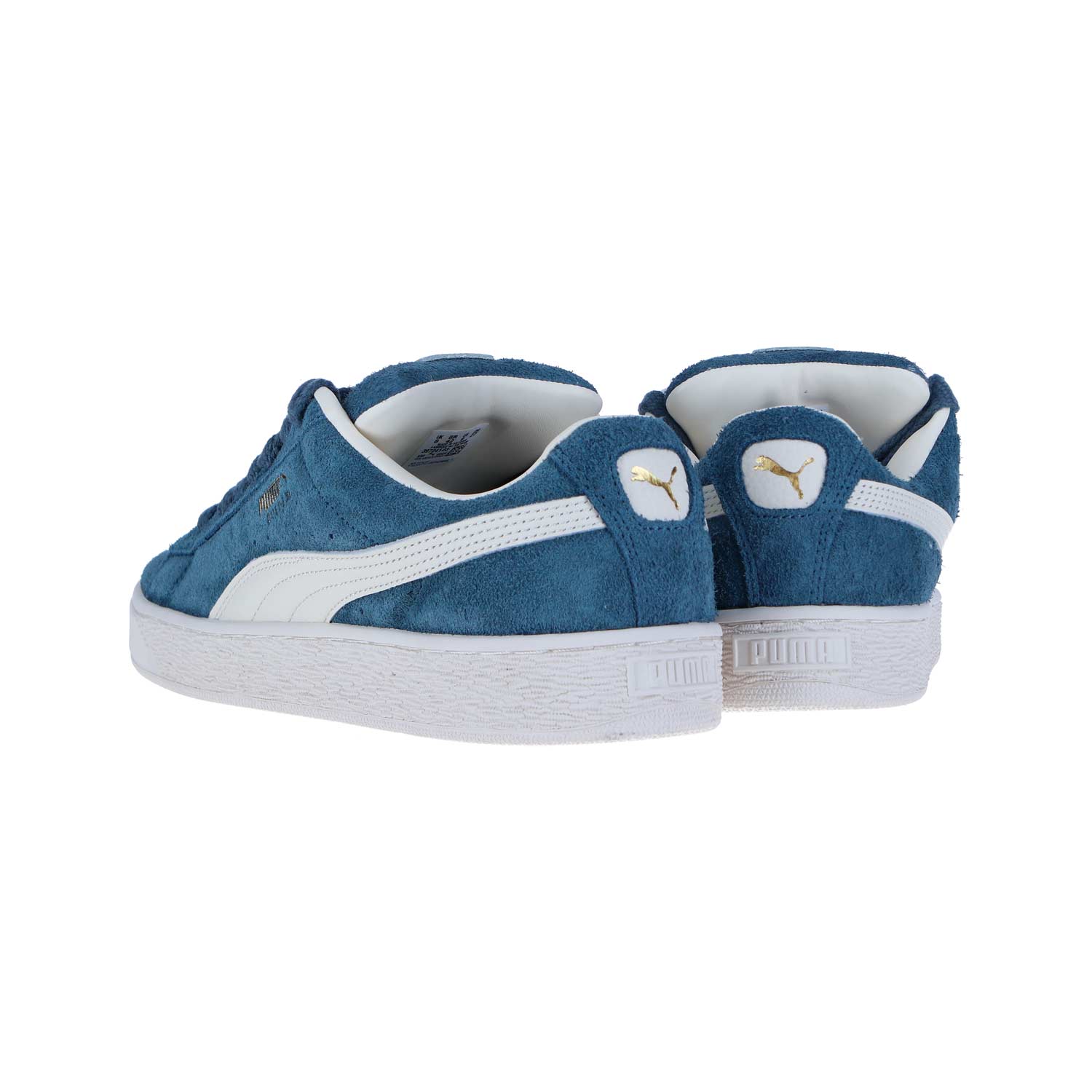 Ein Paar PUMA Suede XL Hairy Sneakers aus blauem Wildleder mit weißer Gummisohle, weißen PUMA-Streifen und goldenen Fersenlogos vor einem weißen Hintergrund.