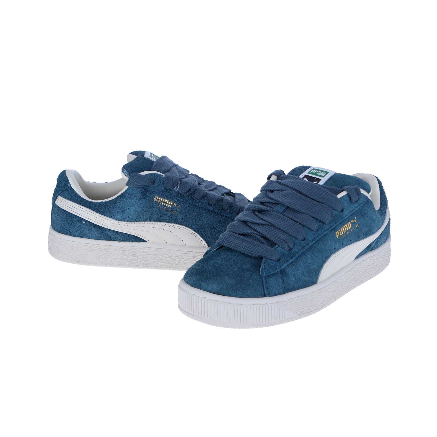 Ein Paar PUMA Suede XL Hairy Sneakers aus blauem Wildleder mit weißen Akzenten, goldenem Puma-Logo an der Seite und einer weißen Gummisohle. Ein Schuh zeigt nach vorne, während der andere zur Seite geneigt ist.