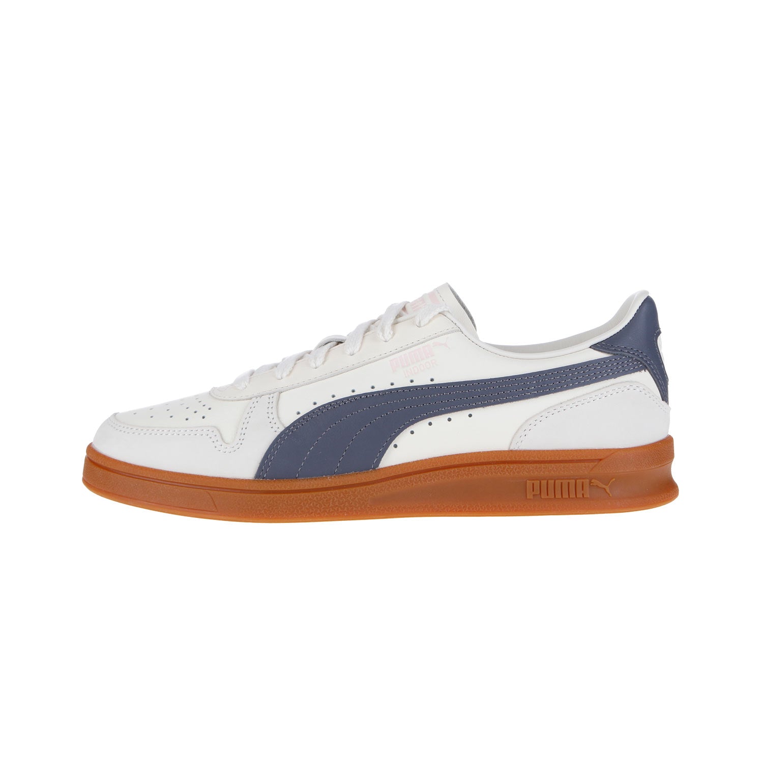 Der Puma Indoor OG MN in mattiertem Elfenbein/Galaktikgrau hat ein weißes Obermaterial aus Leder, marineblaue Streifen, perforierte Details und eine braune Gummisohle, die im Seitenprofil vor weißem Hintergrund zu sehen ist.