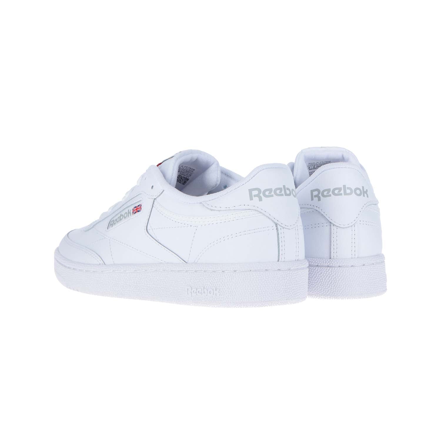 Ein Paar Reebok CLUB C 85 WMN Turnschuhe aus weißem/hellgrauem Leder ist auf einem weißen Hintergrund abgebildet, wobei ein Schuh nach vorne zeigt und der andere gedreht ist, um das Reebok-Logo an der Ferse und an der Seite zu zeigen.