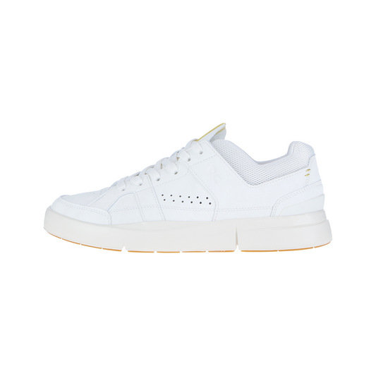Der ROGER CLUBHOUSE White/Gecko MN von On ist ein weißer Low-Top-Sneaker mit perforierten Details, weißen Schnürsenkeln und einer klobigen Sohle. Er ist aus Natur- und Synthetiktextilien gefertigt, hat einen Kragen aus Mesh und dezente goldene Akzente an der Ferse.