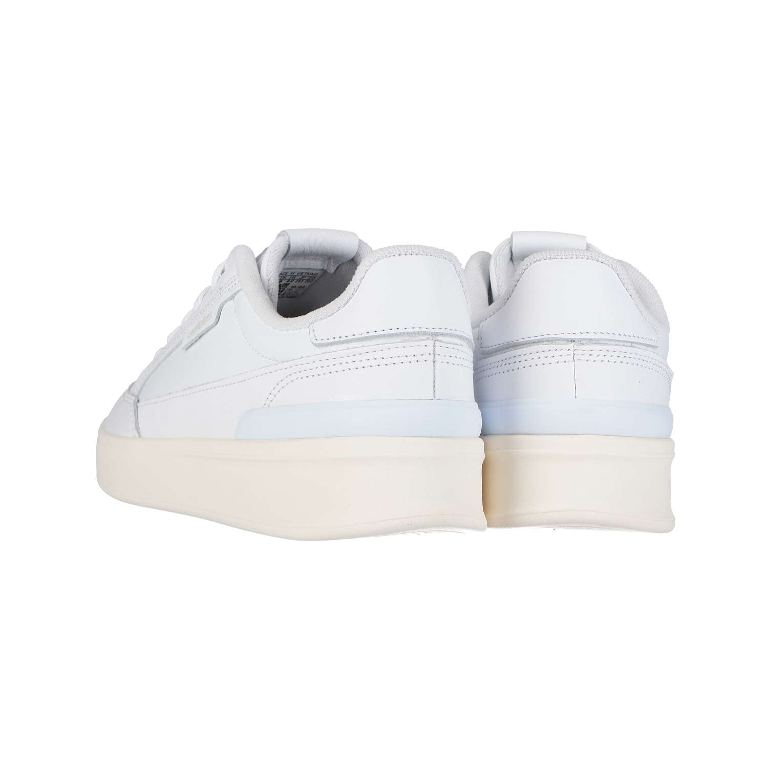 Ein Paar Adidas ASPYRE WHITE MN Low-Top-Sneakers mit cremefarbener Laufsohle, von hinten und leicht seitlich gesehen, wobei die Ferse und ein Teil der weißen Seitenteile zu sehen sind.