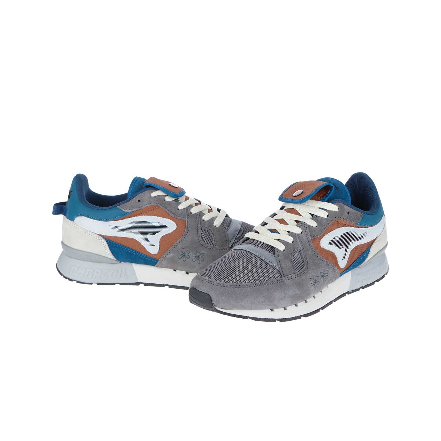 Die KangaROOS Coil R1 GORP Steel Grey/DK Navy MN Sneakers haben ein graues, blaues und braunes Obermaterial aus Synthetik, weiße Schnürsenkel und ein Känguru-Logo an der Seite, alles auf weißem Hintergrund.