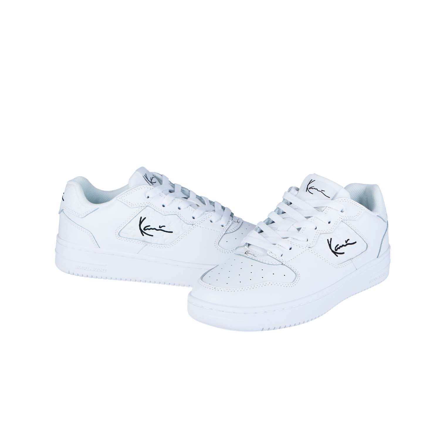 Ein Paar 89 Classic WHITE MN Sneakers von Karl Kani mit perforierten Zehen, weißen Schnürsenkeln und schwarzem Logo auf hochwertigem Leder. Reflektiert den eleganten Look von Urban Styles Agency. Abgebildet auf einfarbig weißem Hintergrund.
