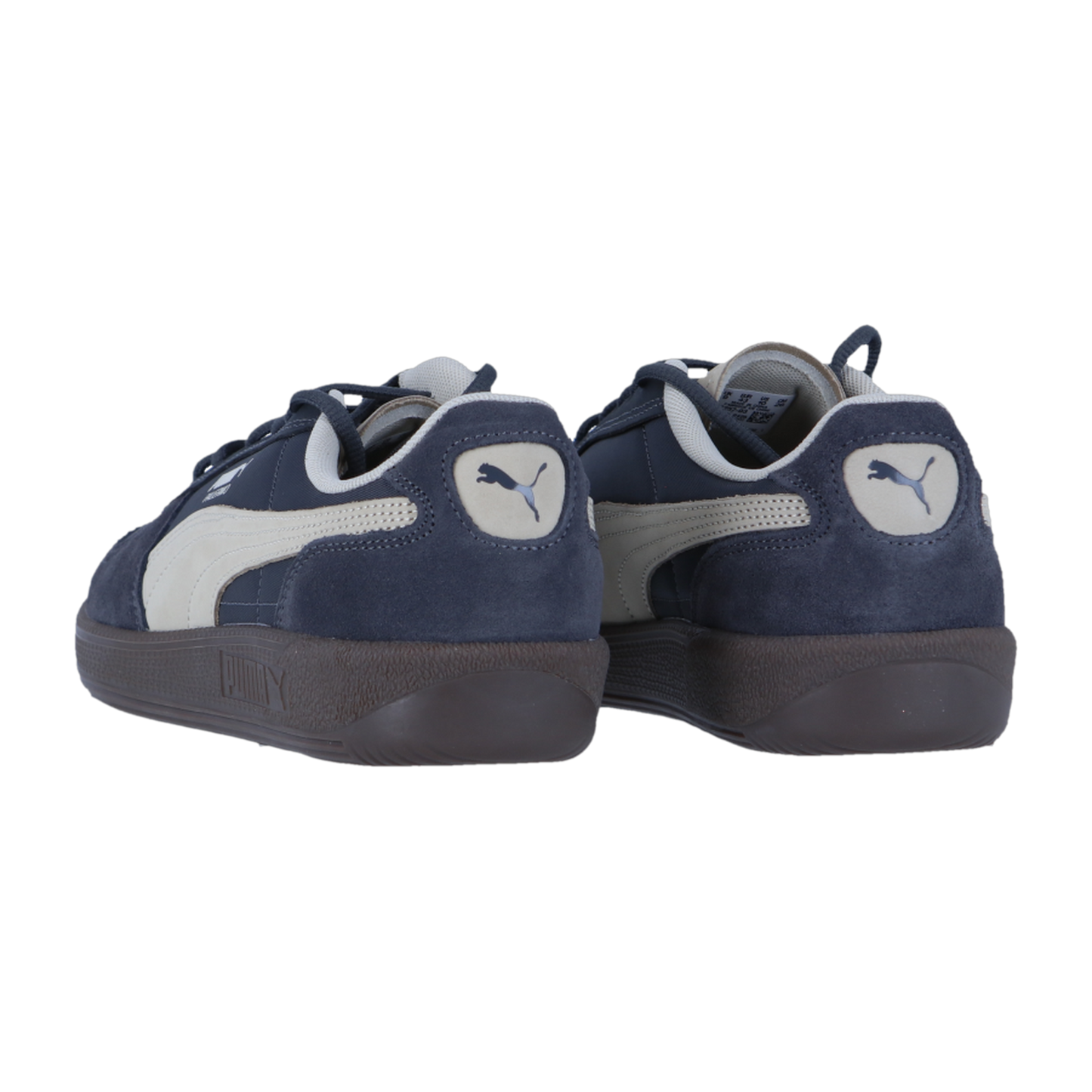 Die Puma Palermo Pop Sneakers haben marineblaues Wildleder, weiße Seitenstreifen mit Logo, dunkelbraune Gummisohlen und sind vor einem weißen Hintergrund zu sehen.