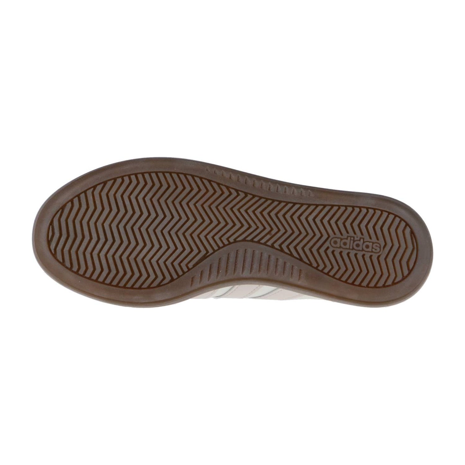 Das Bild zeigt die braune Gummisohle des Adidas BARREDA DECODE LUX Schuhs mit einem Fischgrätenprofil und einem geprägten adidas Logo im Fersenbereich.