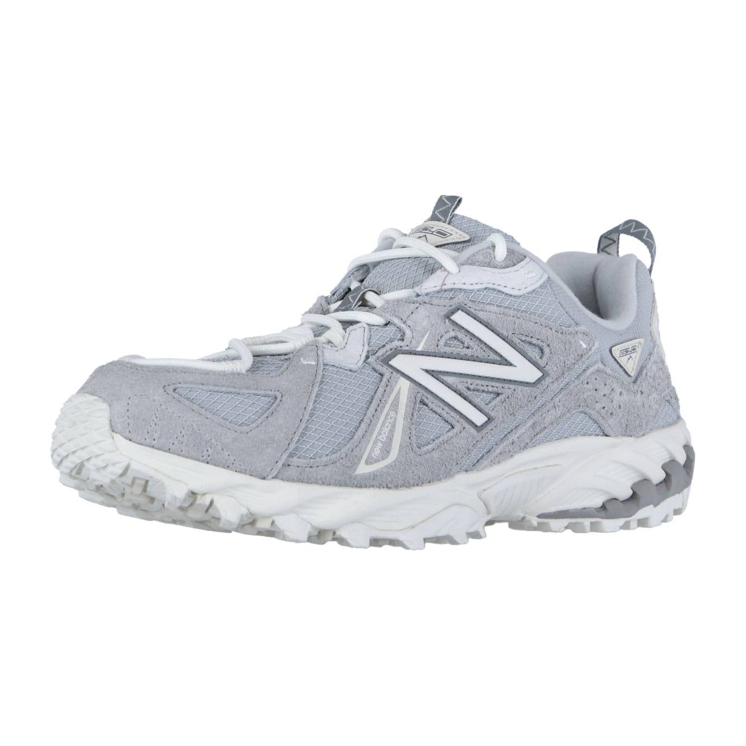 Der New Balance ML610TV1 Trail-Sneaker hat ein hellgraues und weißes Design mit einer dicken, strukturierten Sohle, ABZORB-Zwischensohlentechnologie und einem fetten N-Logo an der Seite, das aus einem leichten Winkel gezeigt wird.