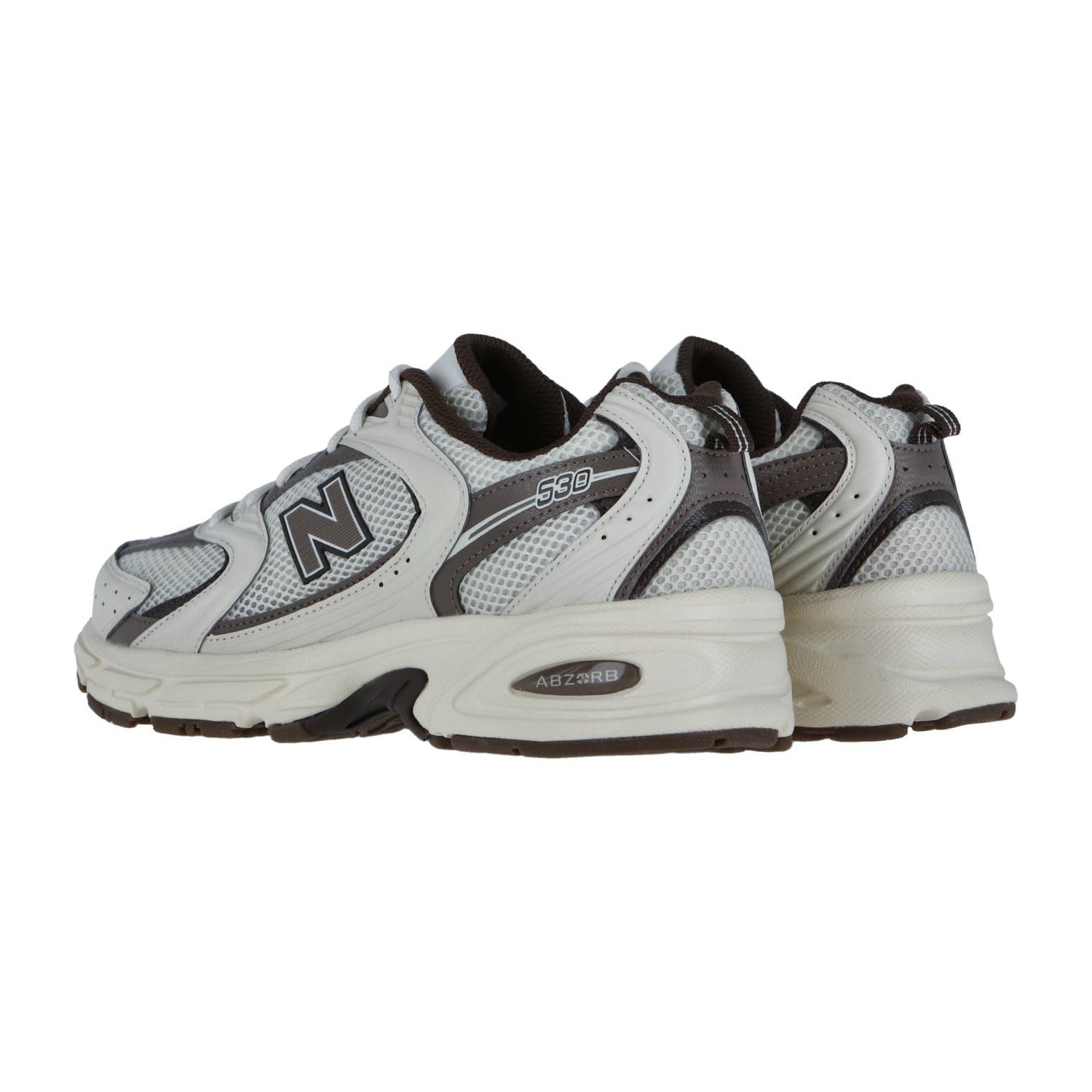 Ein Paar New Balance MR530 Sneakers in Weiß und Grau mit schwarzen und silbernen Akzenten, Obermaterial aus Mesh und Synthetik und klobigen Sohlen, schräg gezeigt.