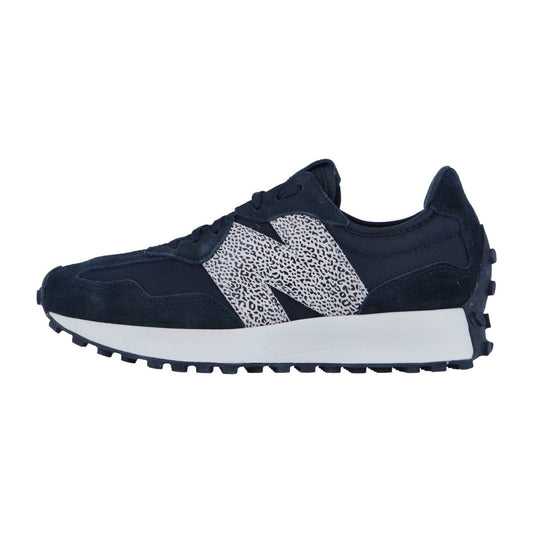 Der New Balance WS327V1 ist ein marineblauer Damen-Sneaker mit weißer Sohle, einem auffälligen weißen N-Logo mit schwarzen Sprenkeln, einer robusten Außensohle und tonalen marineblauen Schnürsenkeln für einen klassischen Retro-Look.
