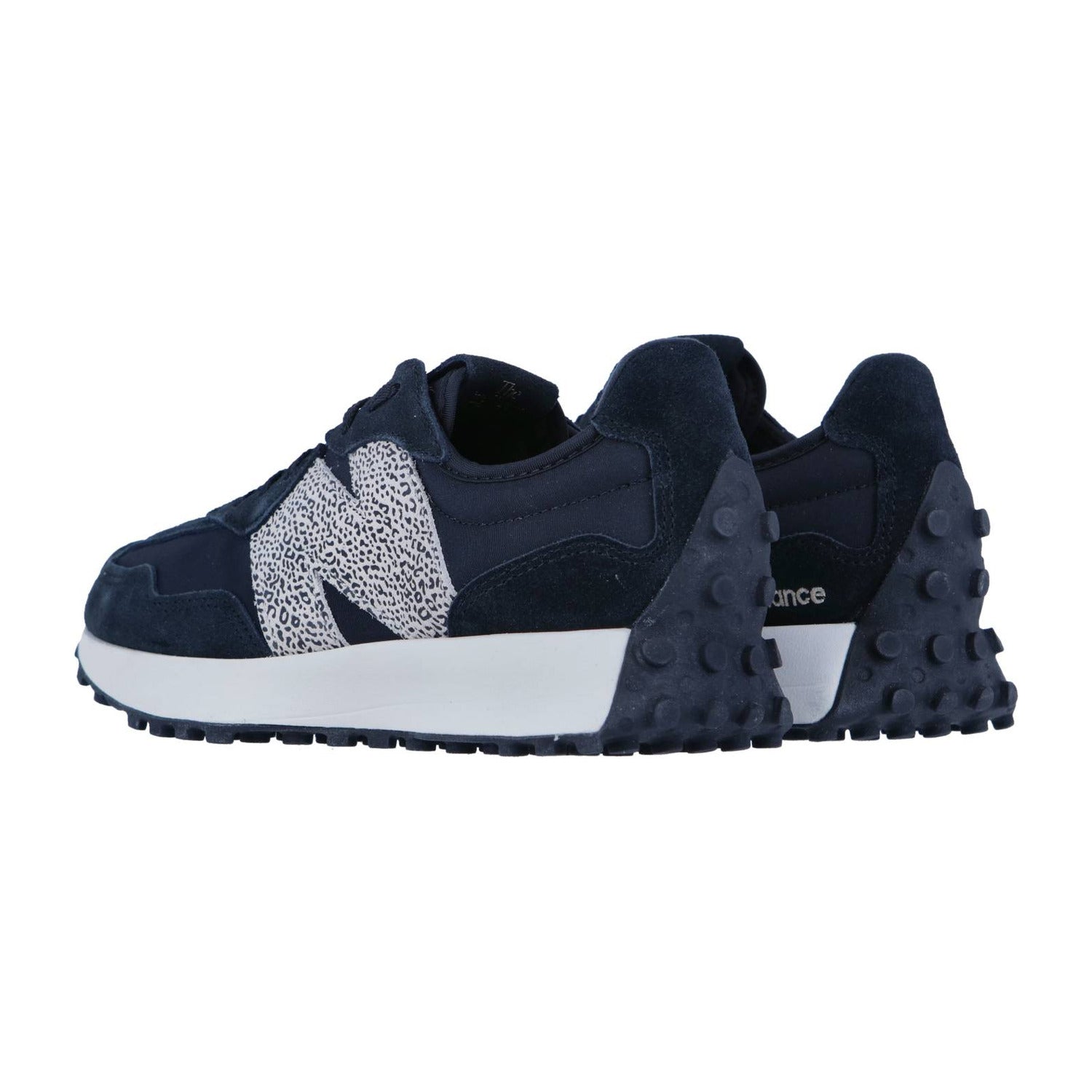 Ein Paar New Balance WS327V1 Turnschuhe in Marineblau mit weiß und schwarz gesprenkeltem N-Logo, dicker weißer Zwischensohle und dunkler strukturierter Laufsohle, gezeigt aus einem Blickwinkel von hinten.