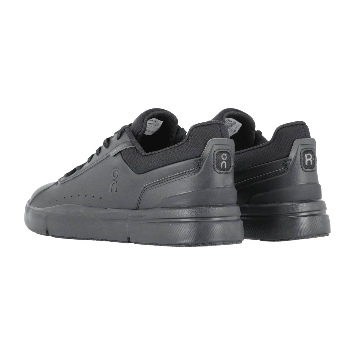 Ein Paar schwarze THE ROGER ADVANTAGE Sneakers von On mit ON- und RC-Logo an den Fersen, von hinten betrachtet, die das Low-Top-Design, die gepolsterten Sohlen und die Schweizer Performance-Technologie hervorheben.