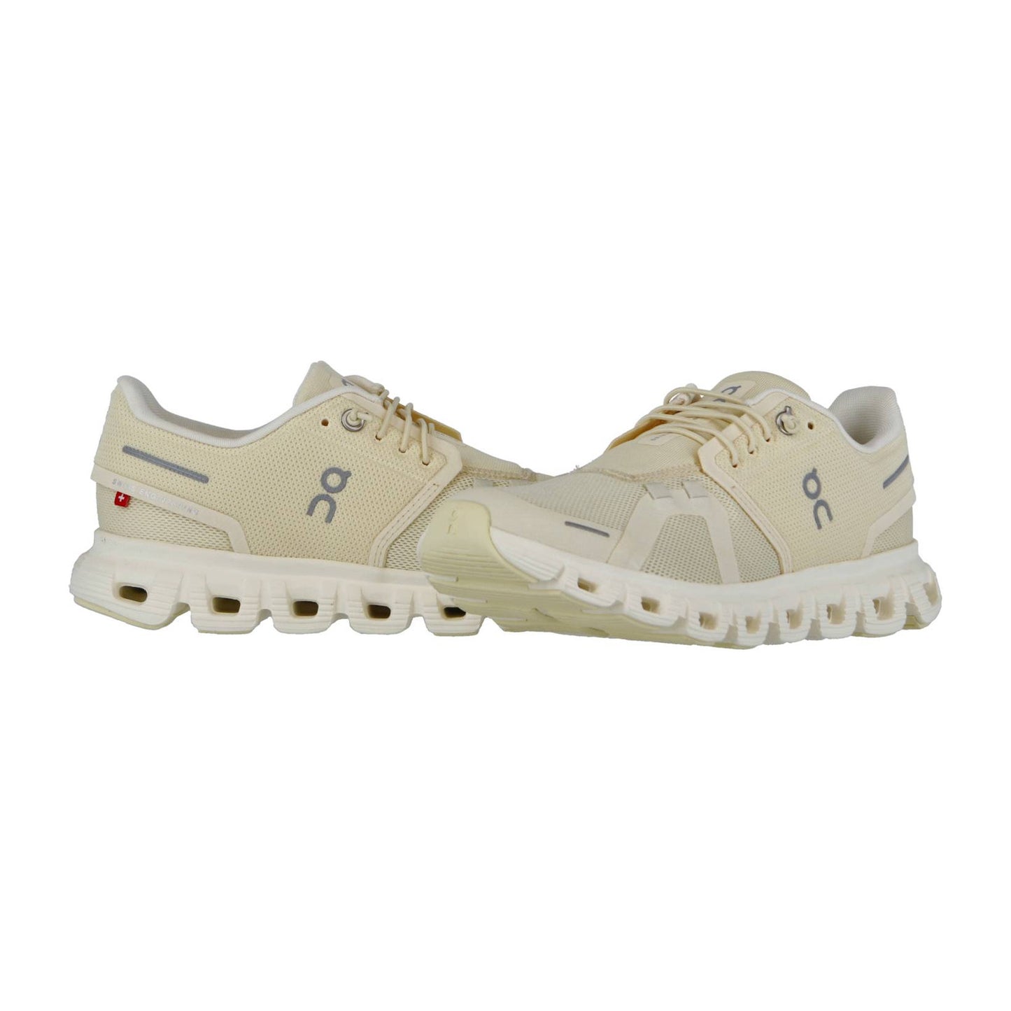 Ein Paar On CLOUD 6 Laufschuhe in Beige mit grauen Akzenten und CloudTec-Dämpfung mit segmentierten Sohlen sind nebeneinander auf weißem Hintergrund abgebildet.