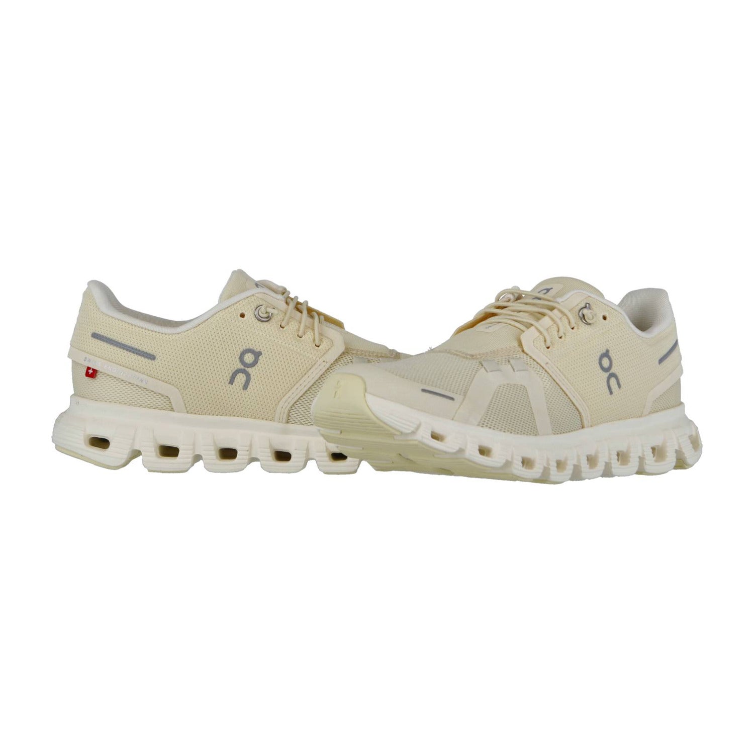 Ein Paar On CLOUD 6 Laufschuhe in Beige mit grauen Akzenten und CloudTec-Dämpfung mit segmentierten Sohlen sind nebeneinander auf weißem Hintergrund abgebildet.
