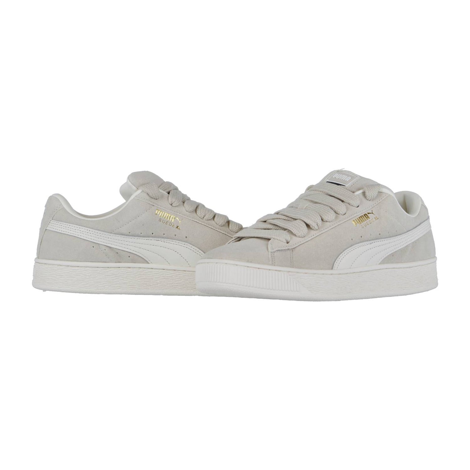 Die Puma Suede XL Sneakers in Hellgrau haben eine weiße Sohle, weiße Puma-Streifen und ein goldenes Branding an der Seite. Sowohl von der Seite als auch von schräg vorne sind sie eine stylische Retro-Ergänzung für jede Streetwear-Sneaker-Kollektion.