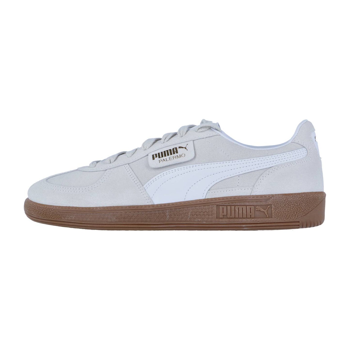 Seitenansicht des Puma Palermo Sneakers in Hellgrau mit weißen Akzenten und einer braunen Gummisohle, mit dem Puma Logo und dem Palermo Branding an den Schnürsenkeln - ein klassischer, von der Terrasse inspirierter Style.