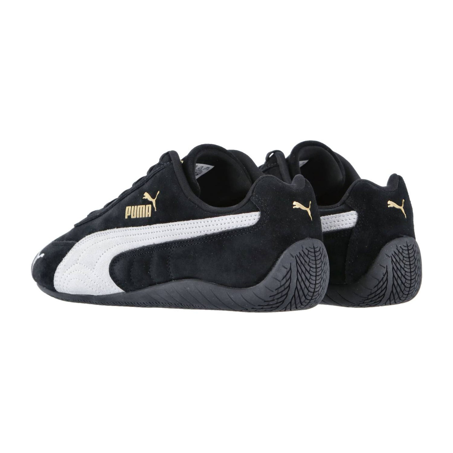 Die Puma Speedcat OG Sneakers zeigen ein schwarzes Design mit weißen Streifen, goldenen Puma-Logos und strukturierten schwarzen Sohlen - von hinten auf weißem Hintergrund, perfekt für einen Racing-Lifestyle Motorsport-Look.