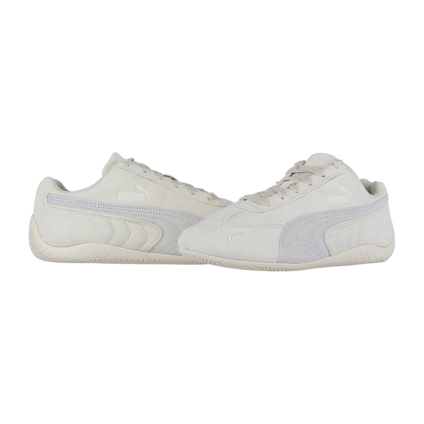 Die Puma Speedcat OG Sneakers zeigen sich in cremefarbenem Wildleder, einem seitlichen Formstrip und dem Puma Logo, inspiriert von klassischen Rennfahrerschuhen. Sie werden auf einem schlichten weißen Hintergrund angezeigt.