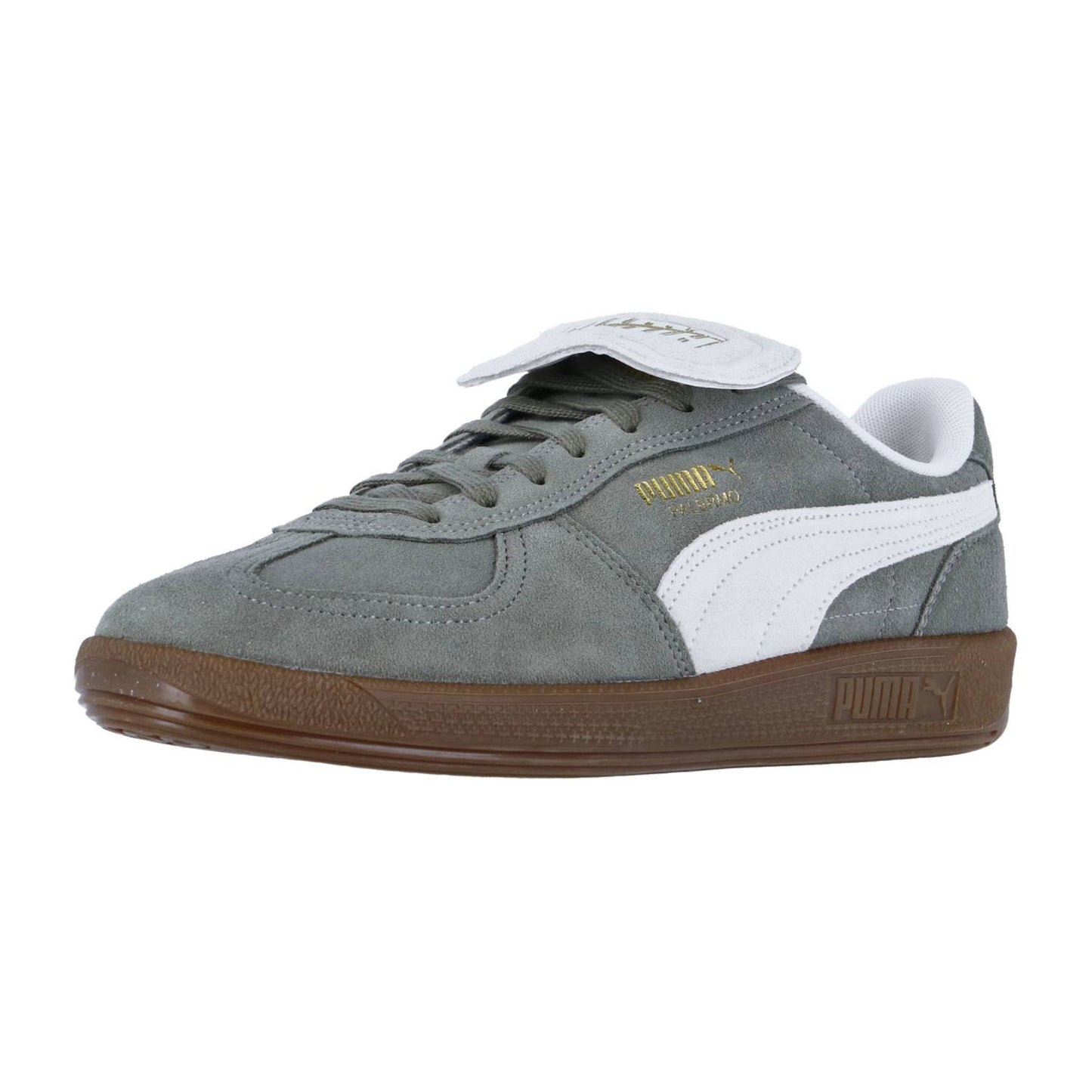 Der Puma Palermo PREMIUM Suede hat graues Wildleder, einen weißen Streifen, eine braune Sohle und eine umklappbare Zunge mit dem Puma-Logo in Gold.