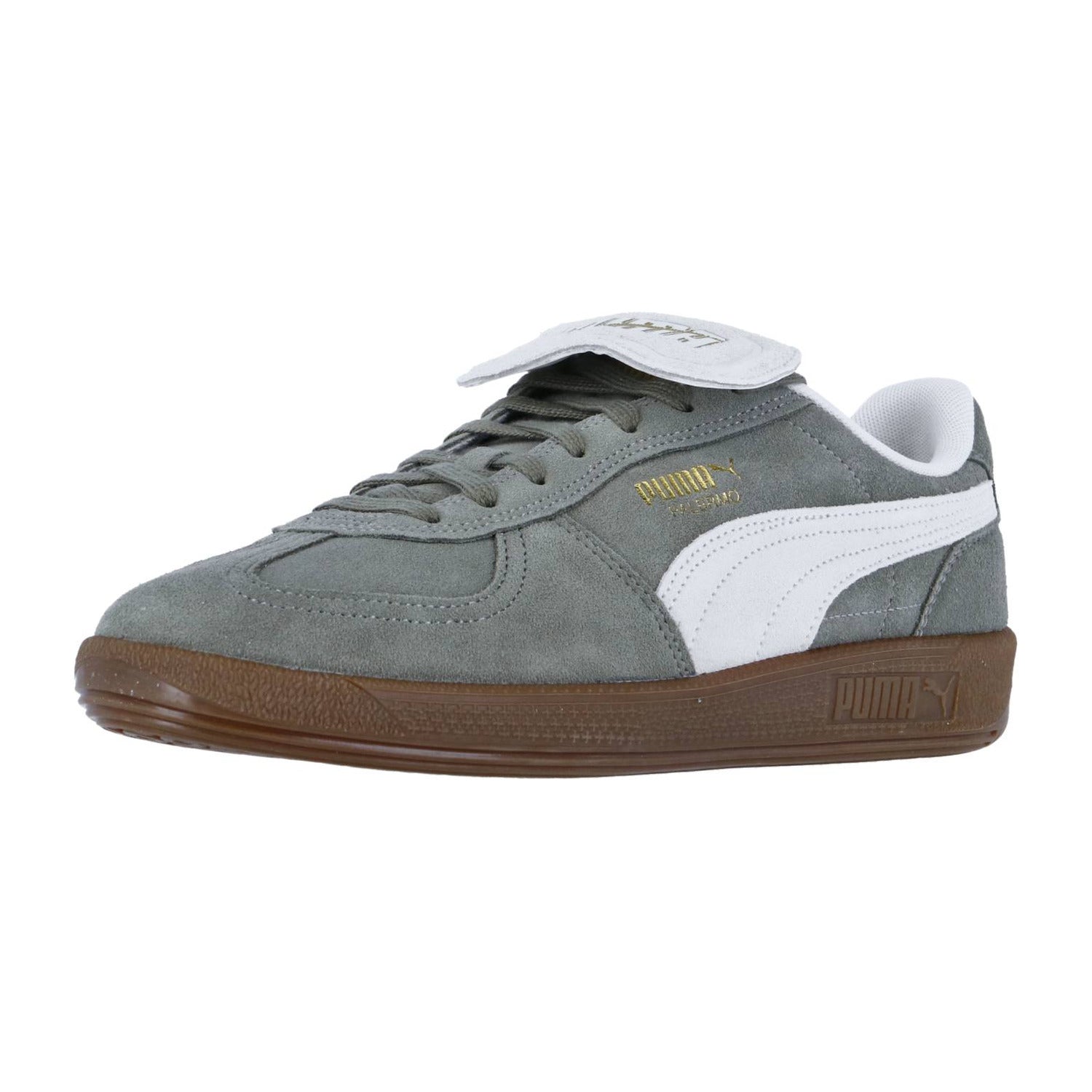 Der Puma Palermo PREMIUM Suede hat graues Wildleder, einen weißen Streifen, eine braune Sohle und eine umklappbare Zunge mit dem Puma-Logo in Gold.