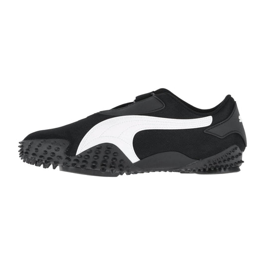Puma Mostro OG Prime: Schwarzer Sport-Sneaker mit markantem weißem Seitenstreifen, strukturierter Gummisohle mit erhabenen Unebenheiten und einer niedrig geschnittenen Silhouette, von der Seite vor weißem Hintergrund dargestellt.