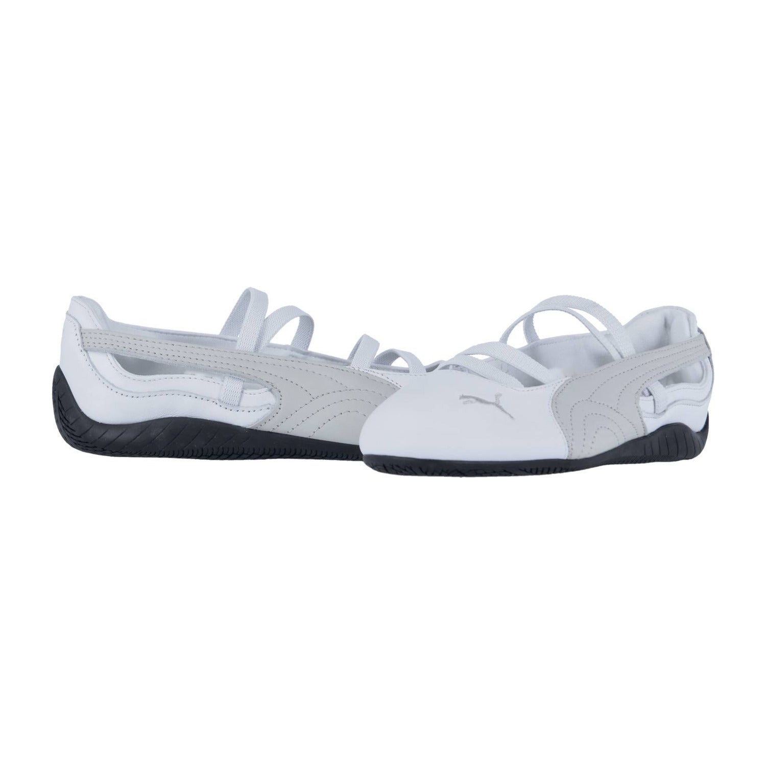Ein Paar weiße Puma Speedcat Ballet LTH Wns Slip-ons für Damen mit elegantem Lederdesign, dünnen Riemen und schwarzer Gummisohle auf weißem Hintergrund.
