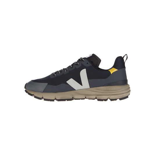 Der Veja Dekkan Alvmesh Black-Oxford Grey-Tonic ist ein sportlicher Sneaker mit einem schwarz-grauen Design, einem weißen V-Logo, einer klobigen beigen Sohle aus Amazonas-Gummi und einem gelben Fersenakzent, der auf einem weißen Hintergrund dargestellt ist.