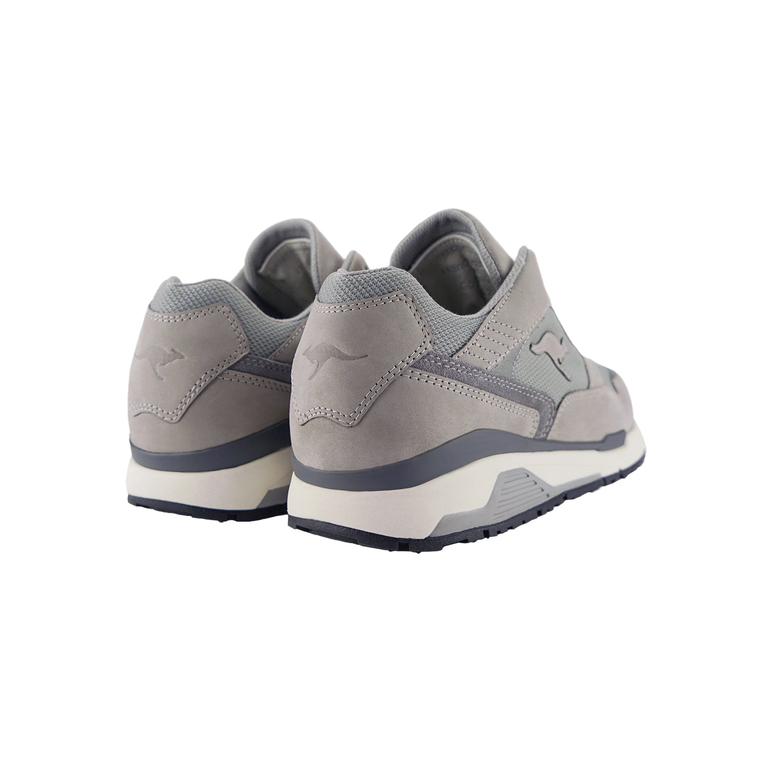 Ein Paar hellgraue KangaROOS Classic Stone-Sneakers mit Känguru-Logo an der Seite und auf der Rückseite, mit DYNACOIL-Dämpfung, aus einem hinteren Winkel vor einem weißen Hintergrund.