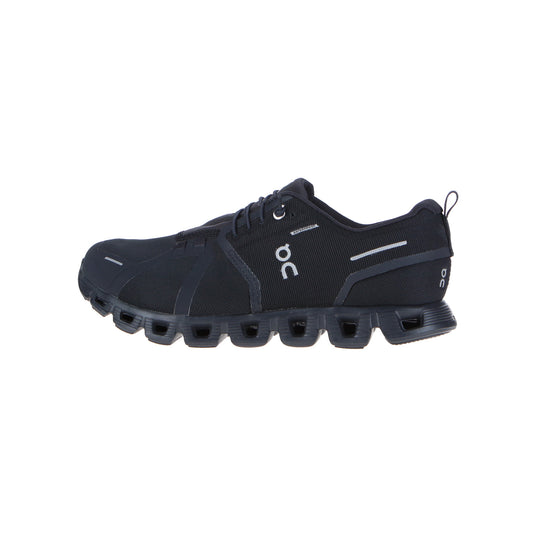 Der On Cloud 5 Waterproof Men All Black ist ein schwarzer, sportlicher Laufschuh mit einem Obermaterial aus recyceltem Polyester-Mesh, einem Schnürverschluss, einer tief gerillten, gepolsterten Sohle mit Hohlprofilen und dem ON-Logo an der Seite.