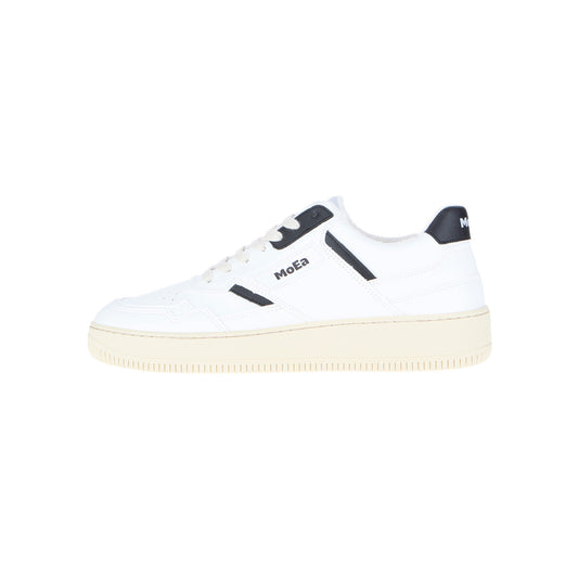 Der MoEa GEN1 Grapes Retro White & Black ist ein nachhaltiger Sneaker mit weißem Obermaterial, schwarzen Akzenten, einer beigen Gummisohle und dem MoEa-Branding an der Seite und an der Ferse auf einem schlichten weißen Hintergrund.