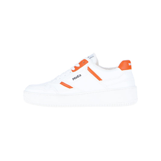 Der GEN1 Orange White & Orange Sneaker von MoEa besteht aus weißem Material mit orangefarbenen Akzenten an der Ferse, den Ösen und den Seiten. Der Low-Top-Schuh hat eine dicke weiße Sohle, ein umweltfreundliches Design und zeigt das typische MoEa-Branding.