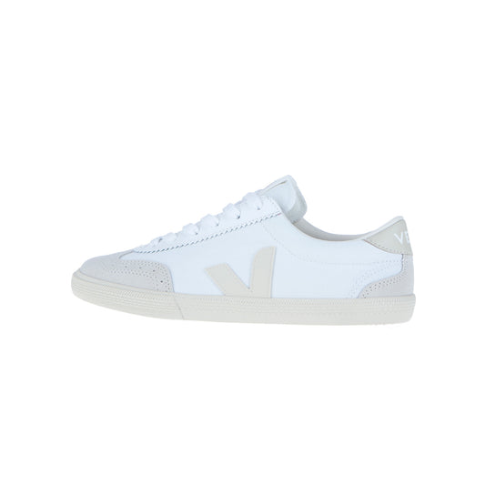 Der Veja Volley Canvas Beige/Weiß ist ein weißer Low-Top-Sneaker mit hellgrauen Akzenten, weißen Schnürsenkeln und einem hellgrauen V-Logo. Er ist aus nachhaltigen Materialien wie Bio-Baumwolle hergestellt, hat eine Gummisohle und ein minimalistisches Design.