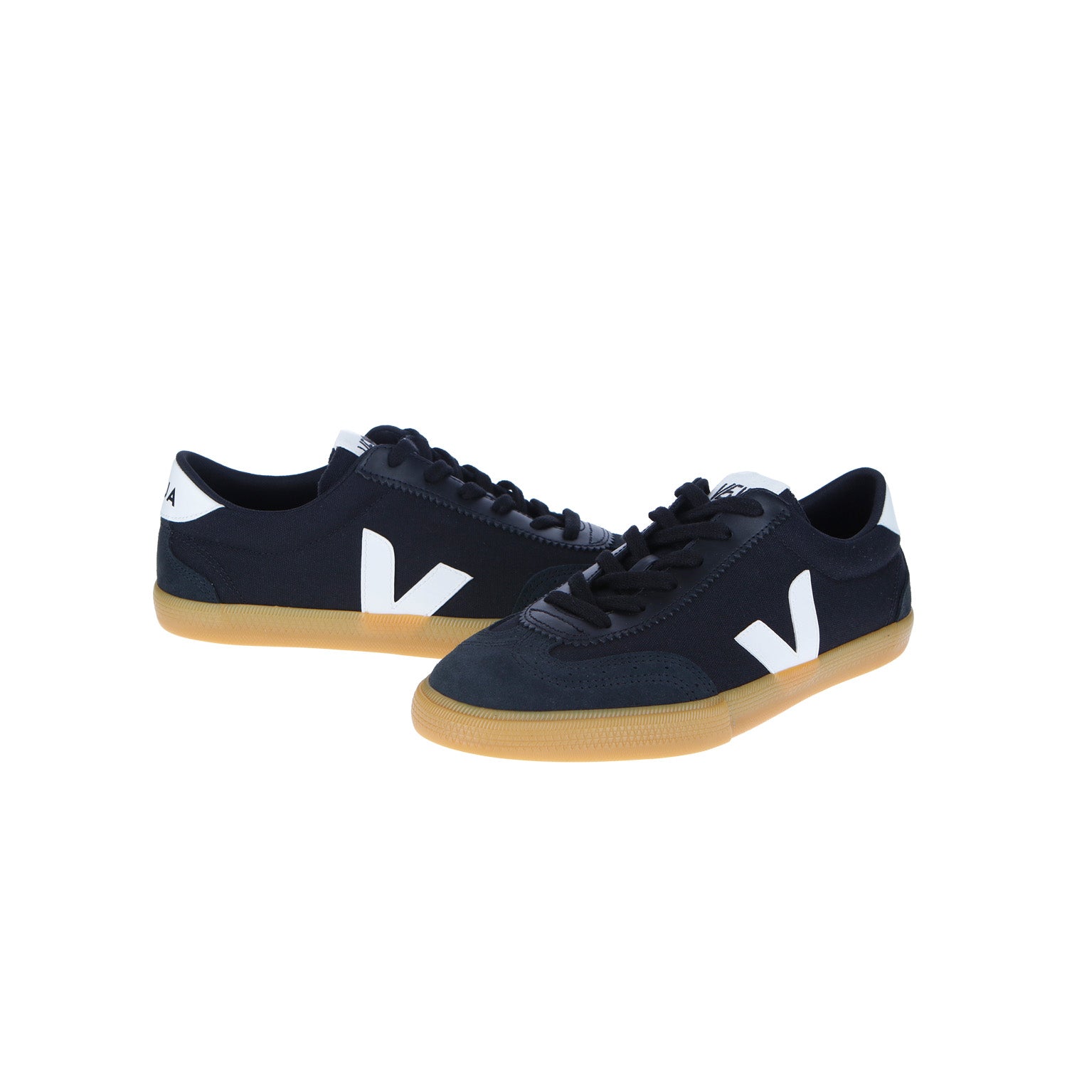 Die Veja Volley Canvas Schwarz/Weiß/Natural Sneakers haben ein schwarzes Low-Top-Design mit weißen Akzenten, charakteristischen weißen V-Logos und natürlichen Gummisohlen. Hergestellt aus nachhaltigen Materialien, werden sie vor einem schlichten weißen Hintergrund angezeigt.