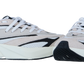 Ein Paar Adidas LIGHTBLAZE Sneaker für Frauen in Weiß und Beige mit schwarzen Akzenten, Mesh-Obermaterial, klobigen weißen Sohlen, weißen Schnürsenkeln und reaktionsfreudiger LIGHTSTRIKE-Technologie, dargestellt auf einem schlichten weißen Hintergrund.