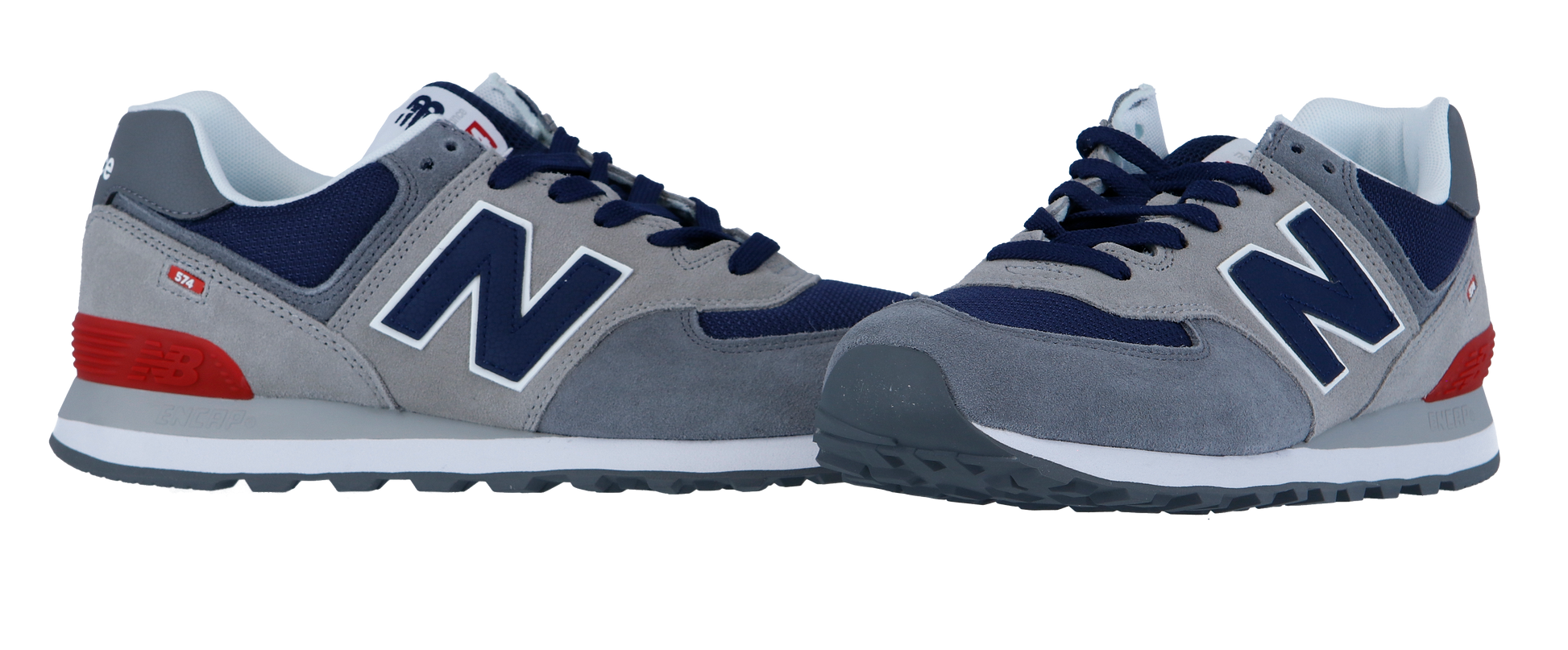 Die New Balance 574 V2 Sneakers in Grau und Marineblau mit roten Akzenten haben eine weiße Zwischensohle mit ENCAP-Dämpfung und eine dunkelgraue Laufsohle, die auf weißem Hintergrund abgebildet ist.