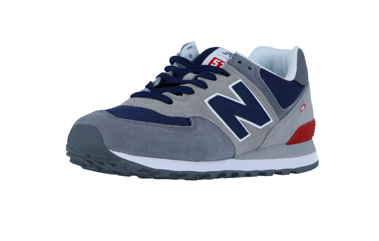 Der New Balance 574 V2 hat graues Wildleder, marineblaue Mesh-Einsätze, dunkelblaue Schnürsenkel, eine weiße Zwischensohle mit ENCAP-Dämpfung, einen roten Fersenakzent und ein charakteristisches N-Logo an der Seite.