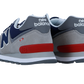 Ein Paar New Balance 574 V2 Sneakers in Grau, Marineblau und Weiß mit roten Akzenten, gezeigt von hinten und von der Seite, mit dem kultigen Fersenlogo und der charakteristischen ENCAP-Zwischensohle für zusätzlichen Komfort.
