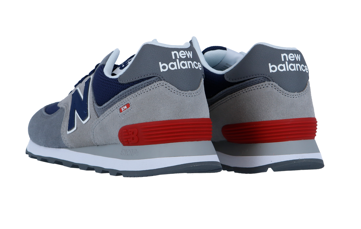 Ein Paar New Balance 574 V2 Sneakers in Grau, Marineblau und Weiß mit roten Akzenten, gezeigt von hinten und von der Seite, mit dem kultigen Fersenlogo und der charakteristischen ENCAP-Zwischensohle für zusätzlichen Komfort.