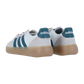 Die adidas BARREDA DECODE LUX Sneakers haben ein weißes Obermaterial, blaugrüne Streifen und Fersenlaschen, beigefarbene Wildlederakzente und dicke Gummisohlen, die von hinten und von der Seite auf einem schlichten weißen Hintergrund zu sehen sind.