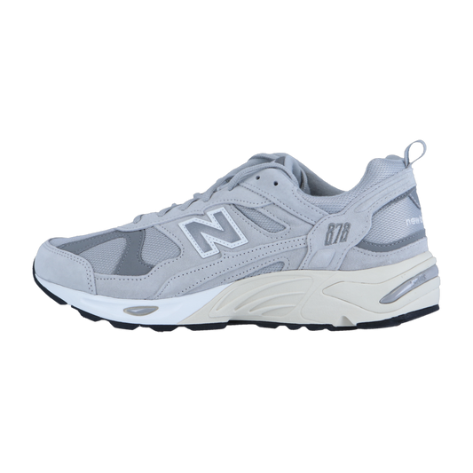 Der New Balance CM878V1 Outdoor-Sneaker hat ein graues Obermaterial aus Mesh und Wildleder mit weißen und silbernen Akzenten, ABZORB-Dämpfung in der Zwischensohle und eine schwarze Laufsohle, die im Seitenprofil vor einem weißen Hintergrund zu sehen ist.