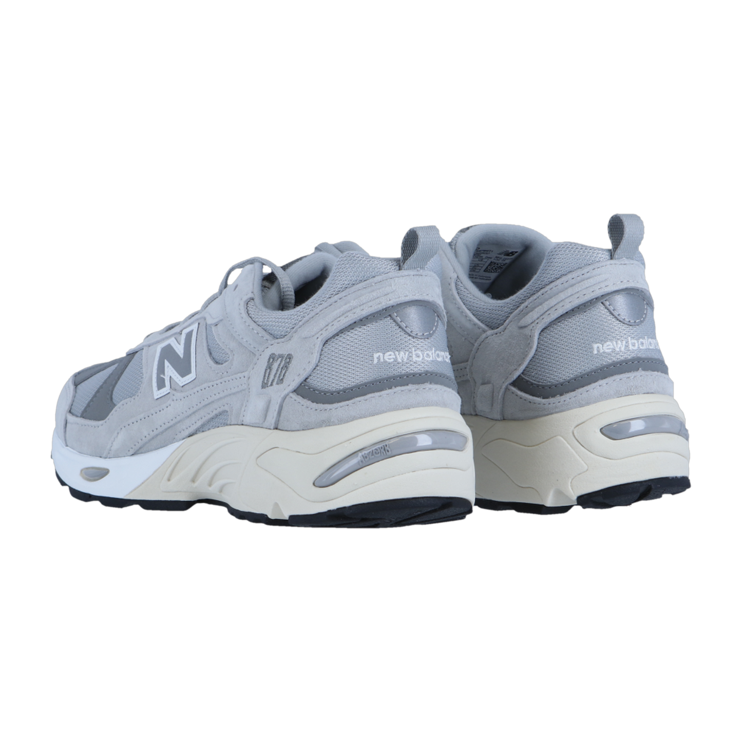 Ein Paar New Balance CM878V1 Sneakers in Grau, abgebildet von hinten und von der Seite, hat eine weiße Zwischensohle mit ABZORB-Dämpfung, eine schwarze Laufsohle, ein N-Logo an der Seite und den Schriftzug "new balance" an der Ferse.