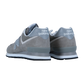 Ein Paar New Balance ML574V3 Sneaker in Grau, von der schrägen Rückseite aus betrachtet, heben das Fersenbranding hervor. Sie sind aus Wildleder und Mesh gefertigt und haben eine weiße Zwischensohle und eine dunkle Laufsohle für einen klassischen Look.