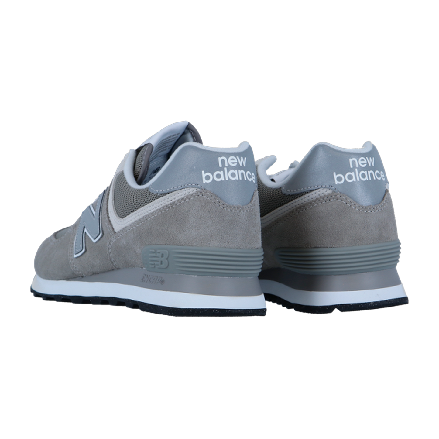 Ein Paar New Balance ML574V3 Sneaker in Grau, von der schrägen Rückseite aus betrachtet, heben das Fersenbranding hervor. Sie sind aus Wildleder und Mesh gefertigt und haben eine weiße Zwischensohle und eine dunkle Laufsohle für einen klassischen Look.