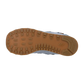 Das Bild zeigt die Unterseite eines New Balance 574 V2-Sneakers mit brauner, strukturierter Gummisohle mit tiefem Profil und dem New Balance-Logo an der Ferse. Der weiße Hintergrund hebt das ENCAP-Dämpfungsdesign hervor.