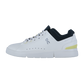 Der ROGER ADVANTAGE von On ist ein weißer Low-Top-Sneaker aus veganem Leder, mit schwarzer Innenausstattung, weißen Schnürsenkeln, seitlichen Perforationen, einem gelben Fersenakzent und ON-Branding in der Nähe der Schnürsenkel. Inspiriert von On's THE ROGER ADVANTAGE Design.