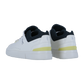 THE ROGER ADVANTAGE Sneakers von On, mit weißem Obermaterial aus veganem Leder, schwarzem Innenfutter, dezenten gelben Fersenakzenten und seitlichen Perforationen, werden von hinten vor einem einfarbigen Hintergrund gezeigt.