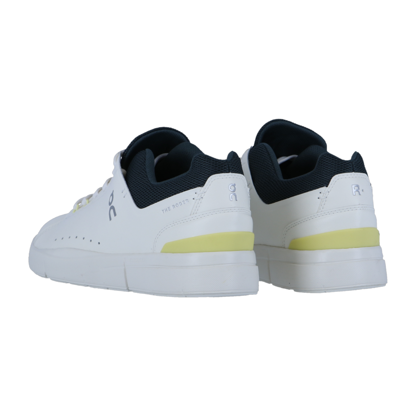 THE ROGER ADVANTAGE Sneakers von On, mit weißem Obermaterial aus veganem Leder, schwarzem Innenfutter, dezenten gelben Fersenakzenten und seitlichen Perforationen, werden von hinten vor einem einfarbigen Hintergrund gezeigt.