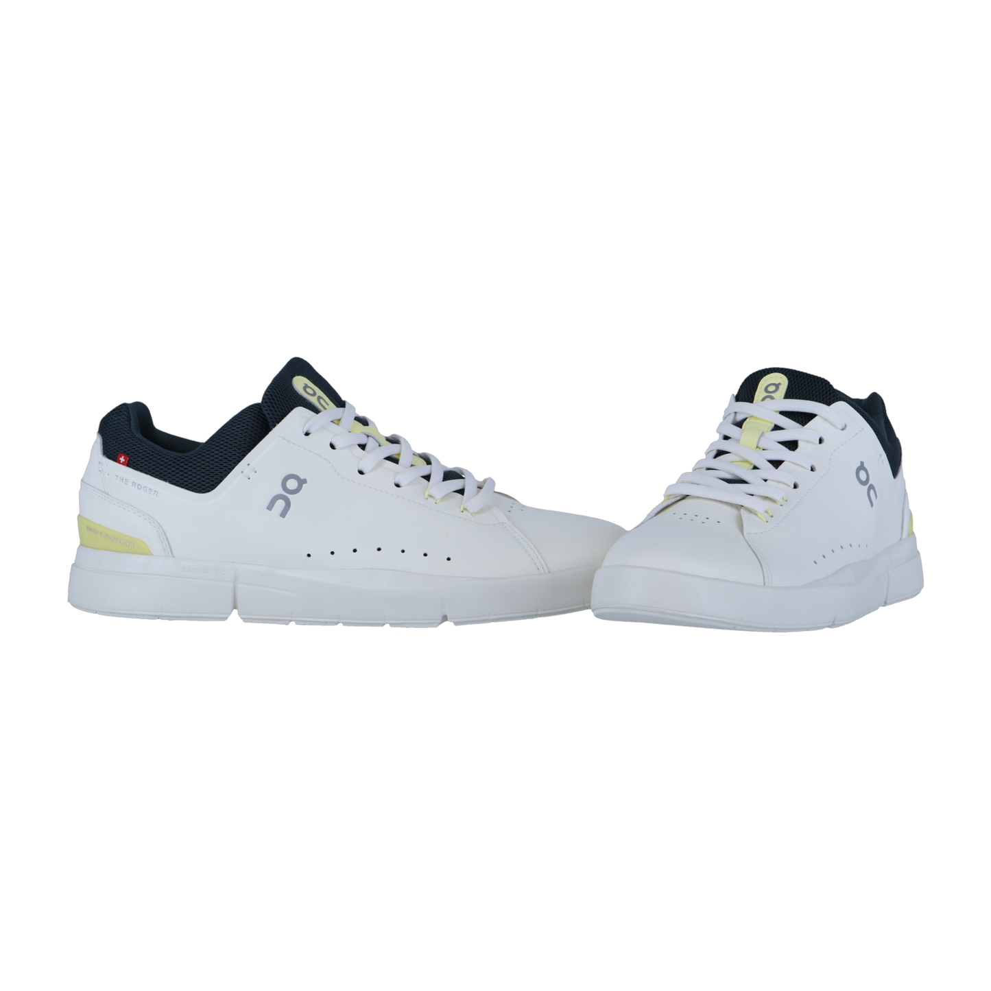 THE ROGER ADVANTAGE von On: Weiße Sport-Sneaker mit schwarzen und gelben Akzenten, gefertigt aus veganem Leder mit perforierten Seiten, Schnürung vorne und einem Low-Top-Design. Auf einfarbig weißem Hintergrund dargestellt.