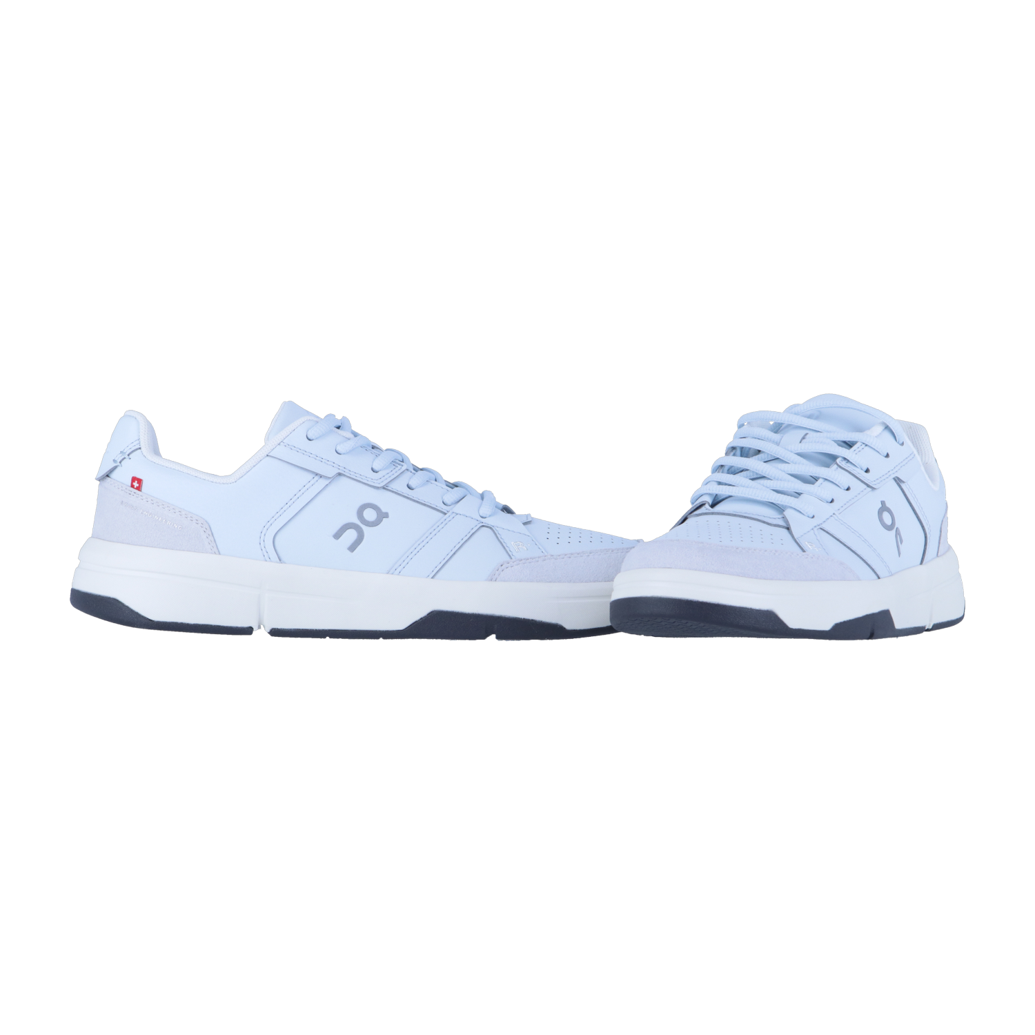 Ein Paar hellblaue THE ROGER CLUBHOUSE Sneakers von On mit weißer Sohle, dunkelblauer Laufsohle und veganem Leder wird nebeneinander auf einem schlichten weißen Hintergrund gezeigt.