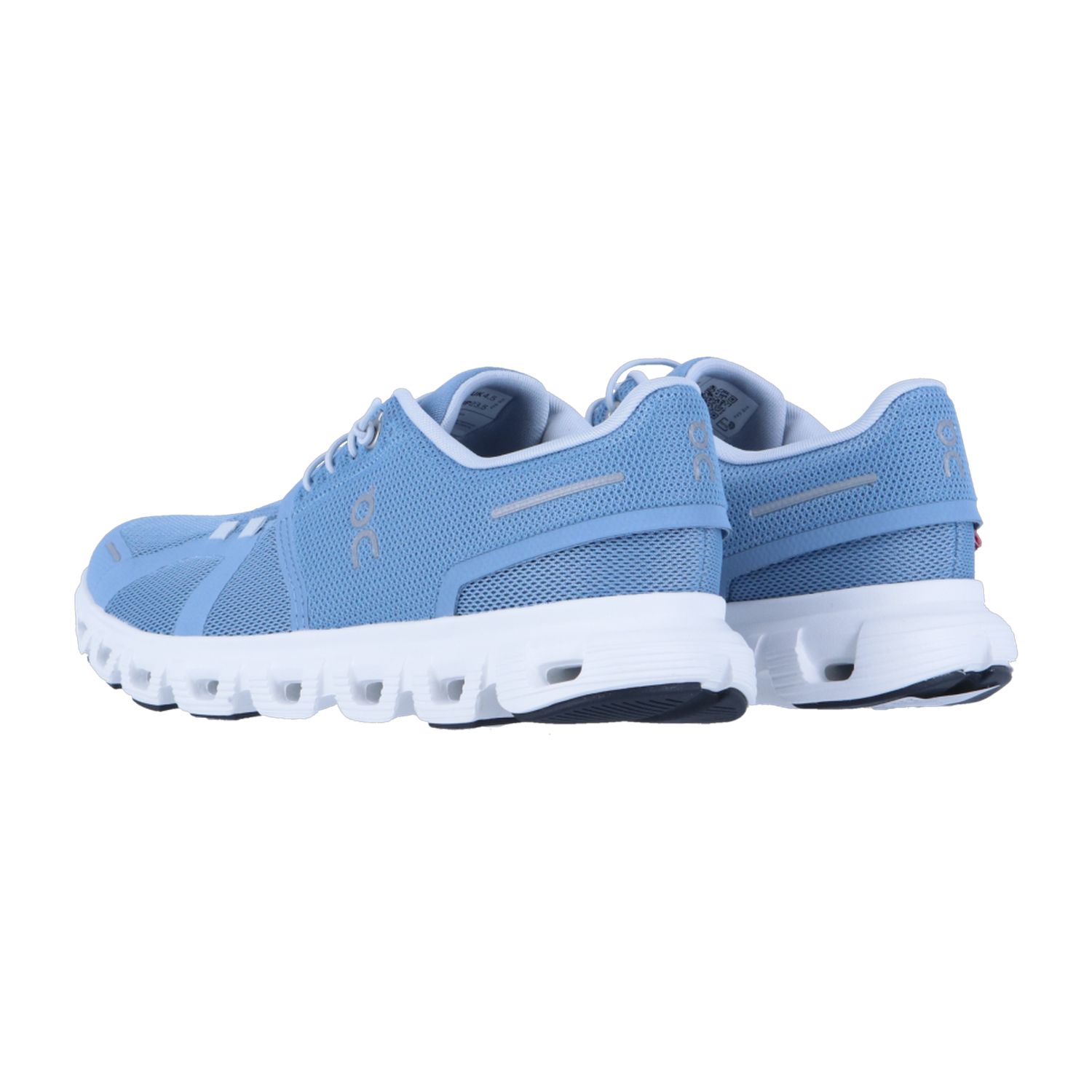 Ein Paar hellblaue On CLOUD 6 Sneakers mit weißer Sohle ist von hinten und von der Seite auf einem weißen Hintergrund zu sehen. Diese Sportschuhe haben ein Obermaterial aus Mesh, ein seitliches Branding und die charakteristische CloudTec-Dämpfung für Komfort.
