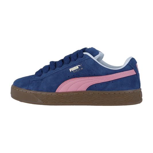 Der Puma Suede XL hat eine Persian Blue-Gum Farbgebung mit einem rosa Streifen, weißem Logo, dunkelblauen Schnürsenkeln und einer braunen Sohle, dargestellt im Seitenprofil auf weißem Hintergrund.